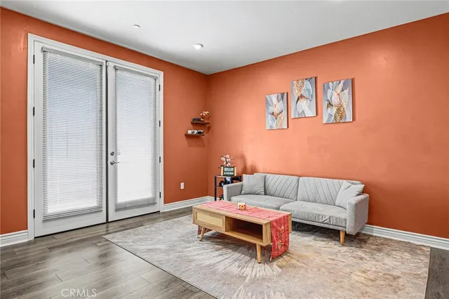 a living room with a couch and a dresser with wooden floor