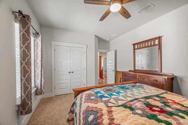 a bedroom with bed and a flat tv screen on dresser