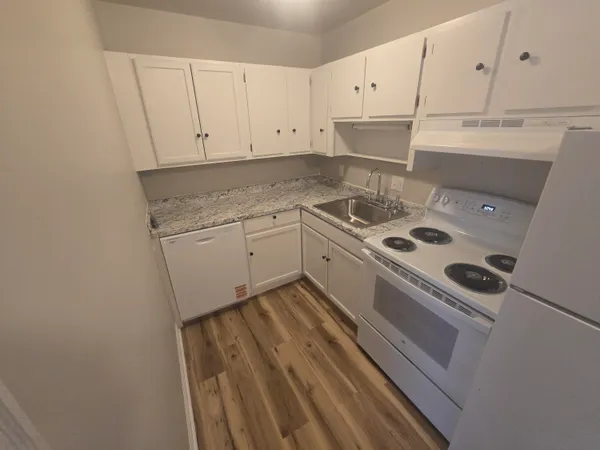 a kitchen with a stove and white cabinets