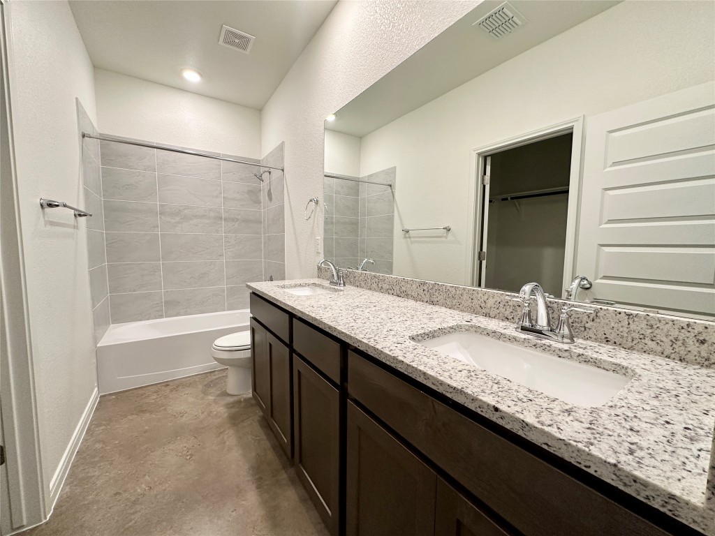 2913 Quail Rdg Lane, Unit A Temple, TX 76501 - Photo 12 of 19 Full bathroom featuring a walk in closet, double vanity, shower combination, and a textured wall