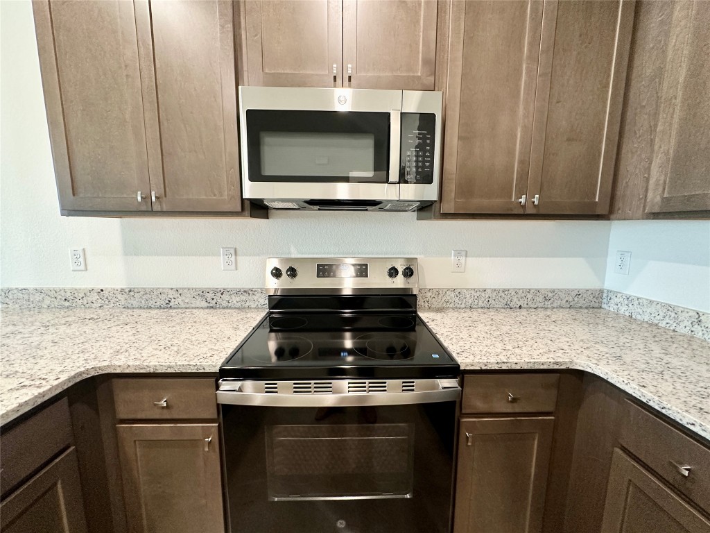 2913 Quail Rdg Lane, Unit A Temple, TX 76501 - Photo 10 of 19 Kitchen featuring stainless steel appliances, light stone counters, and dark brown cabinetry