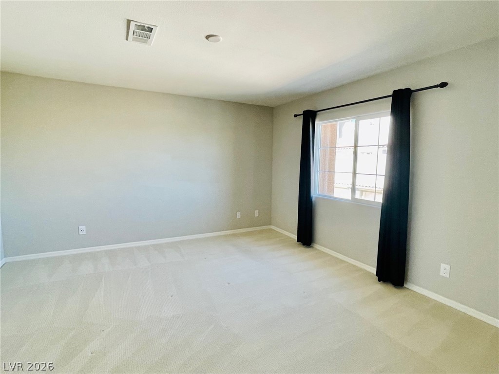 9921 Sable Point Street Las Vegas, NV 89178 - Photo 17 of 43 Soft carpeting pairs with neutral walls and a large window in this versatile primary bedroom space.
