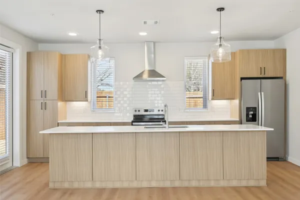 a large kitchen with stainless steel appliances granite countertop a stove a sink and a refrigerator