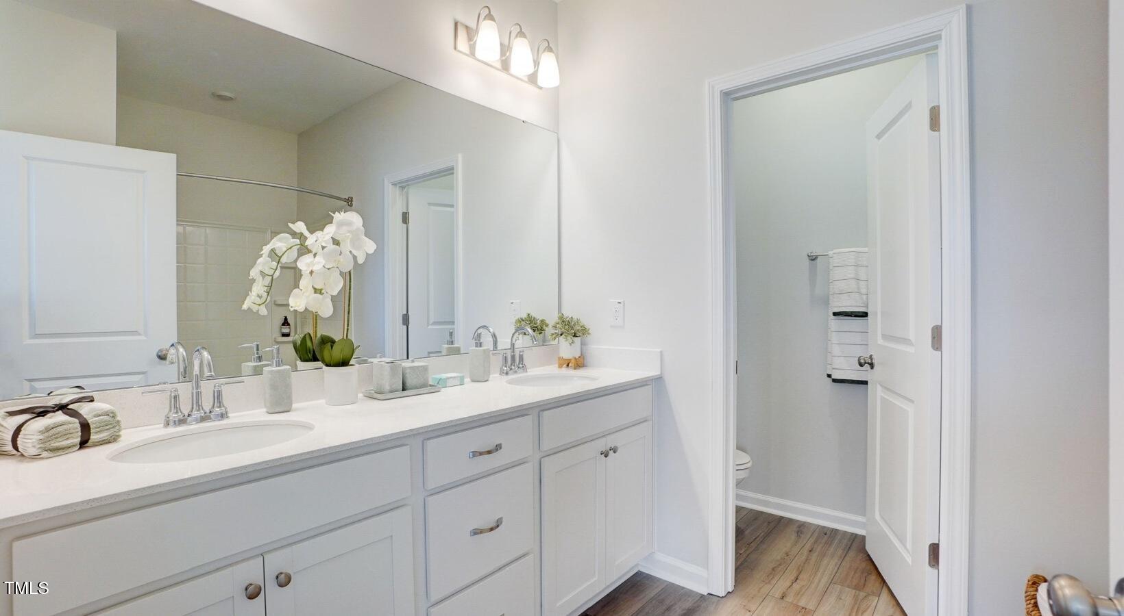 101 Decatur Drive, Unit WATSONIA Raleigh, NC 27603 - Photo 12 of 24 a bathroom with a double vanity sink and mirror