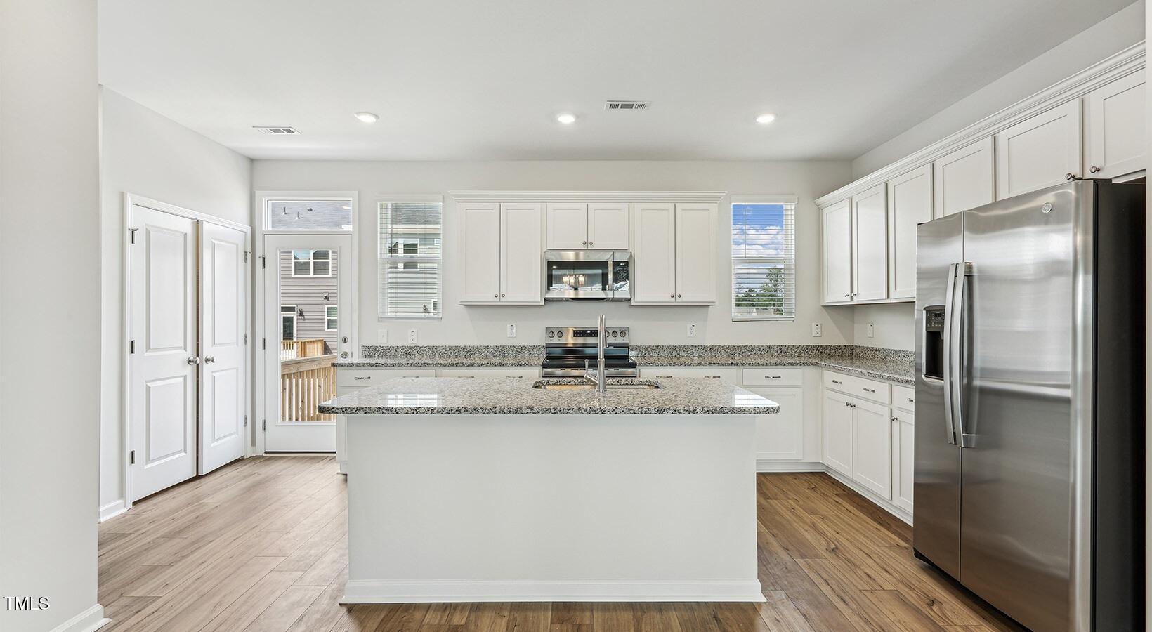 101 Decatur Drive, Unit WATSONIA Raleigh, NC 27603 - Photo 15 of 24 a kitchen with stainless steel appliances granite countertop a refrigerator a stove and a sink