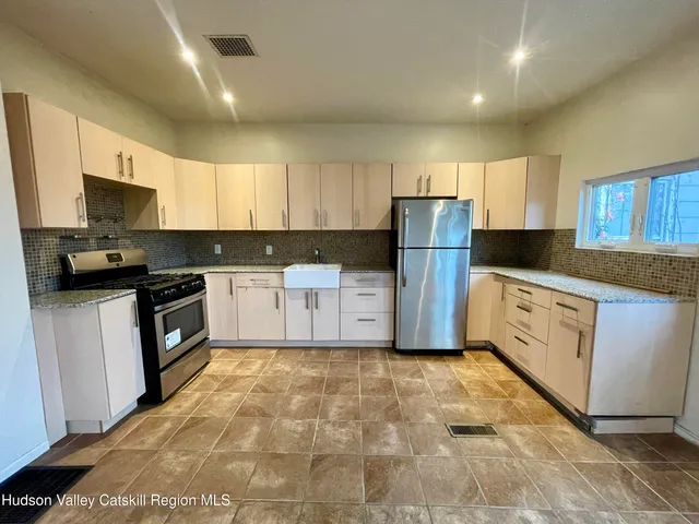 a kitchen with white cabinets and white appliances
