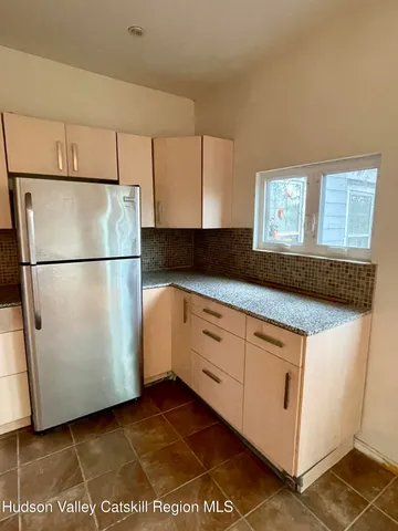 a kitchen with cabinets and a refrigerator