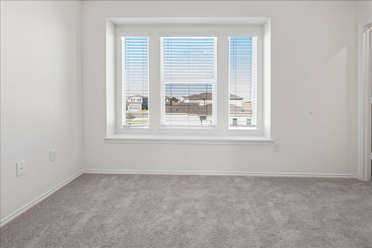 18501 Spotted Eagle Lane Elgin, TX 78621 - Photo 25 of 40 A well-lit room offers cozy carpeting and a broad window with residential views.