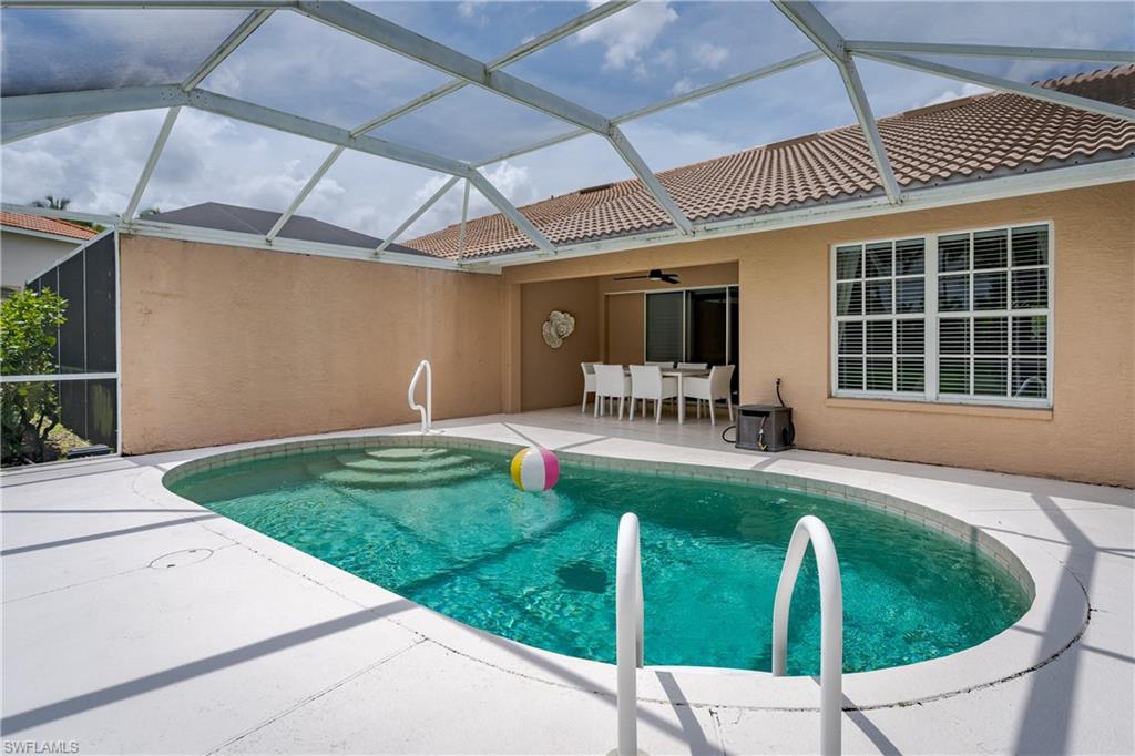 6658 Castlelawn Place, Unit 9 Naples, FL 34113 - Photo 28 of 38 Screened-in patio featuring a kidney-shaped pool with integrated steps, tile roofline, and an expansive concrete deck