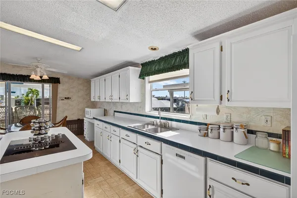 a kitchen with a stove a sink dishwasher and a refrigerator with wooden floor