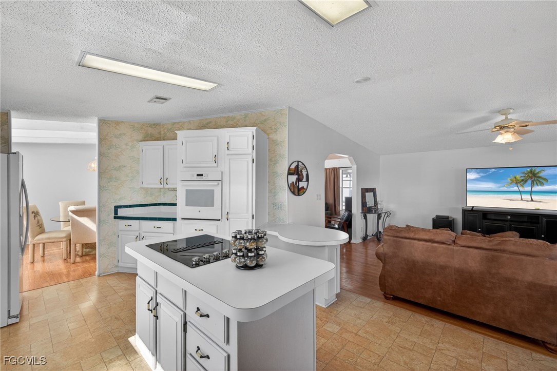 3088 Skipper Lane St. James City, FL 33956 - Photo 12 of 43 a kitchen with a stove a sink dishwasher and a refrigerator with wooden floor
