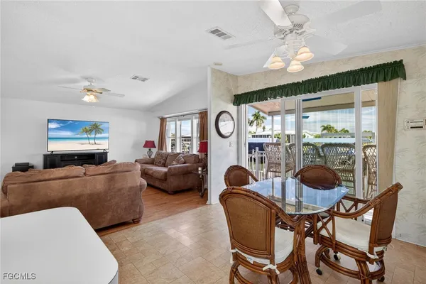 a living room with furniture kitchen view and a wooden floor