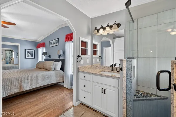 a bathroom with a granite countertop sink a mirror and shower