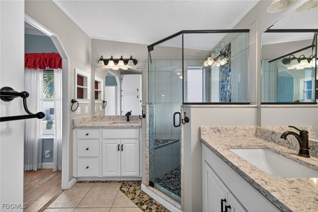 3088 Skipper Lane St. James City, FL 33956 - Photo 25 of 43 a bathroom with a granite countertop double vanity sink mirror and shower