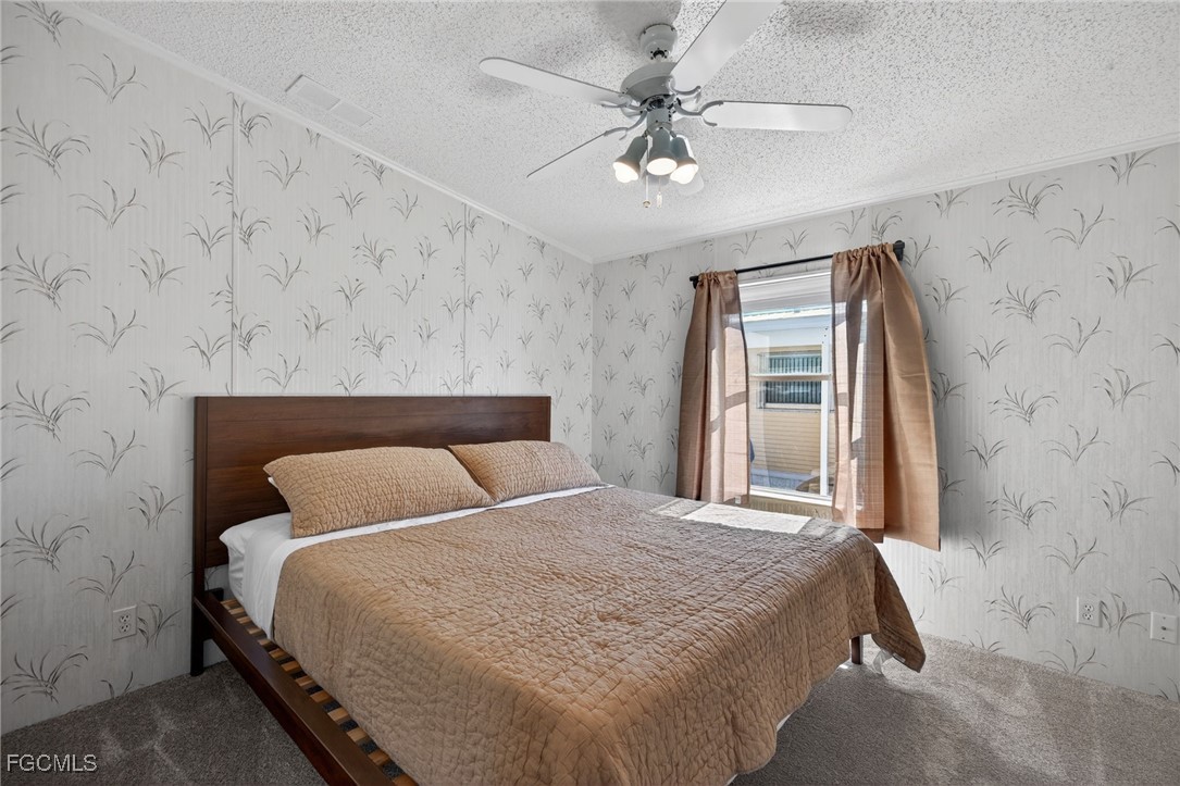 3088 Skipper Lane St. James City, FL 33956 - Photo 27 of 43 a bedroom with a bed and a chandelier