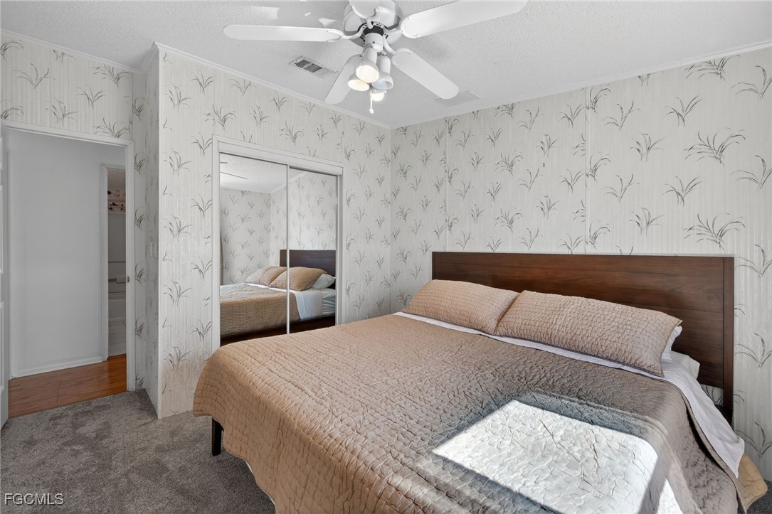 3088 Skipper Lane St. James City, FL 33956 - Photo 28 of 43 a bedroom with a bed and a chandelier