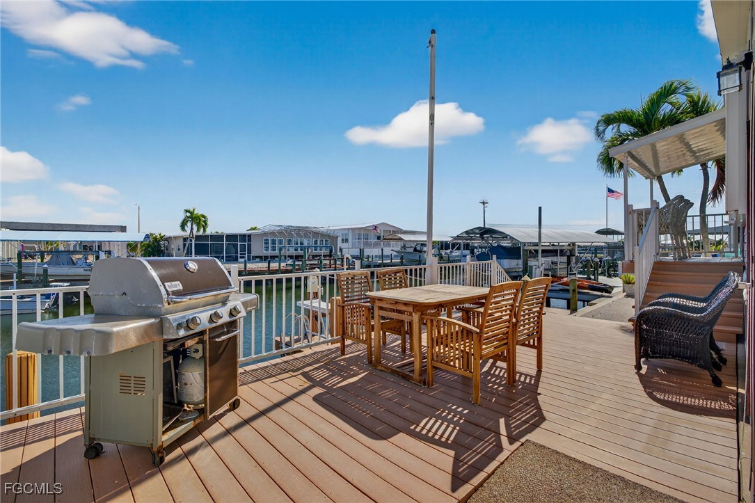 3088 Skipper Lane St. James City, FL 33956 - Photo 33 of 43 a outdoor kitchen with stainless steel appliances granite countertop a stove and a wooden floors