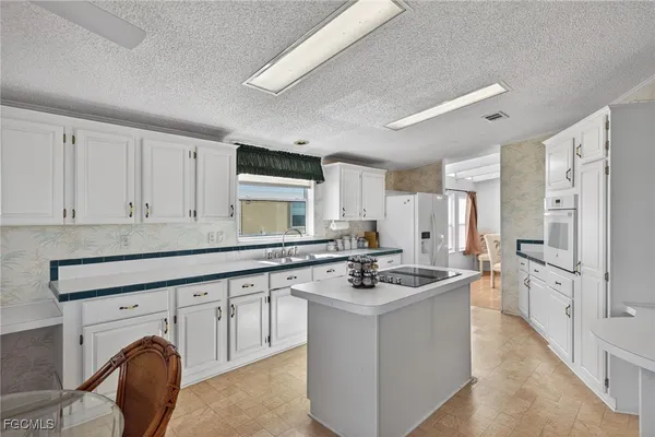 a kitchen with sink a stove and cabinets