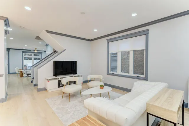 a kitchen with stainless steel appliances granite countertop a stove top oven a sink a dining table and chairs with white cabinets