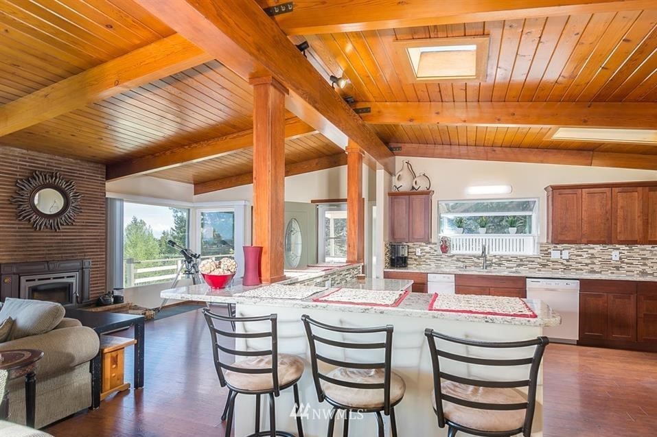 744 Miller Road Sequim, WA 98382 - Photo 20 of 40 a dining room with furniture a fireplace and wooden floor