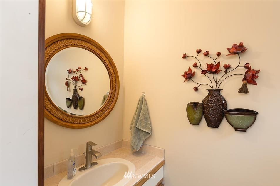 744 Miller Road Sequim, WA 98382 - Photo 26 of 40 a bathroom with a sink a mirror and clock