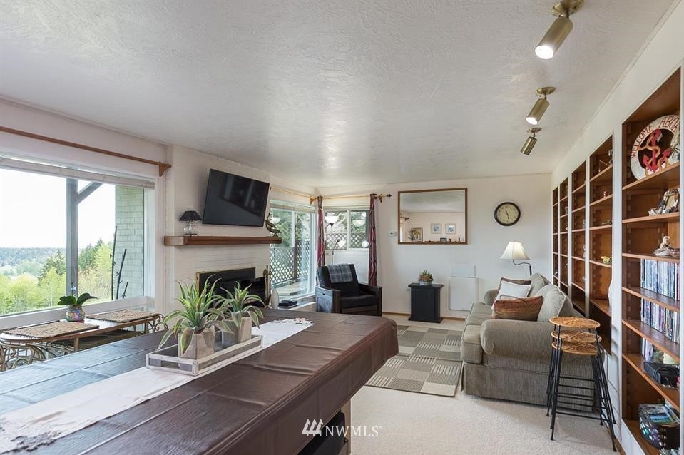 744 Miller Road Sequim, WA 98382 - Photo 29 of 40 a living room with furniture a fireplace and a large window