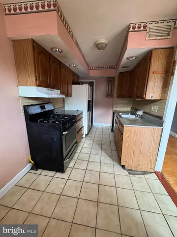 a kitchen with granite countertop a stove a sink and a microwave