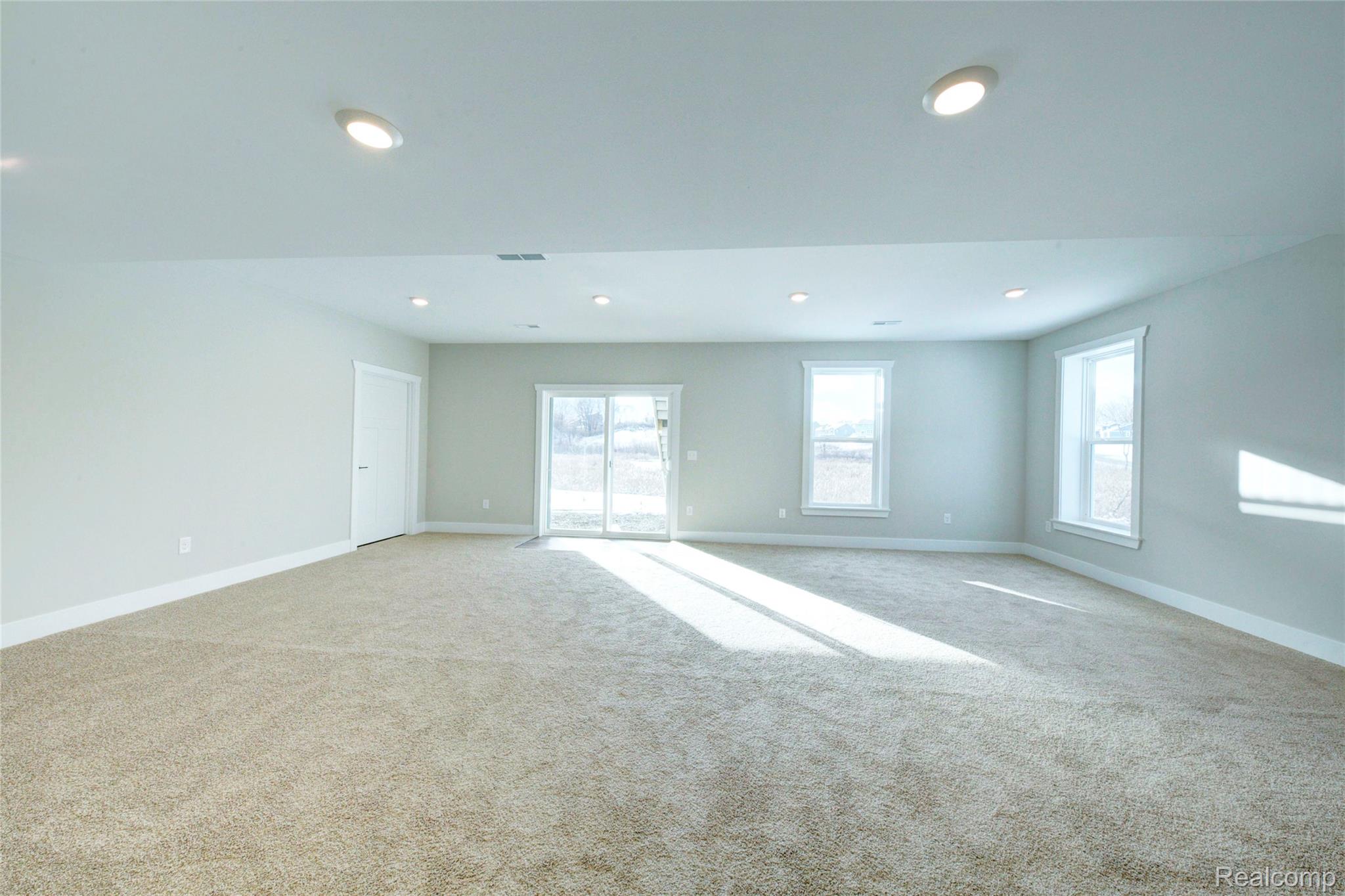 579 Round Rock (moh80) Howell, MI 48843 - Photo 30 of 42 Carpeted empty room featuring plenty of natural light and recessed lighting
