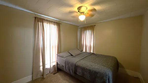 a bedroom with a bed and a chandelier