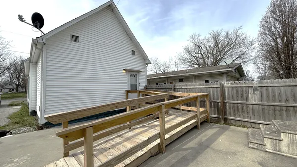 a view of backyard with deck and trees