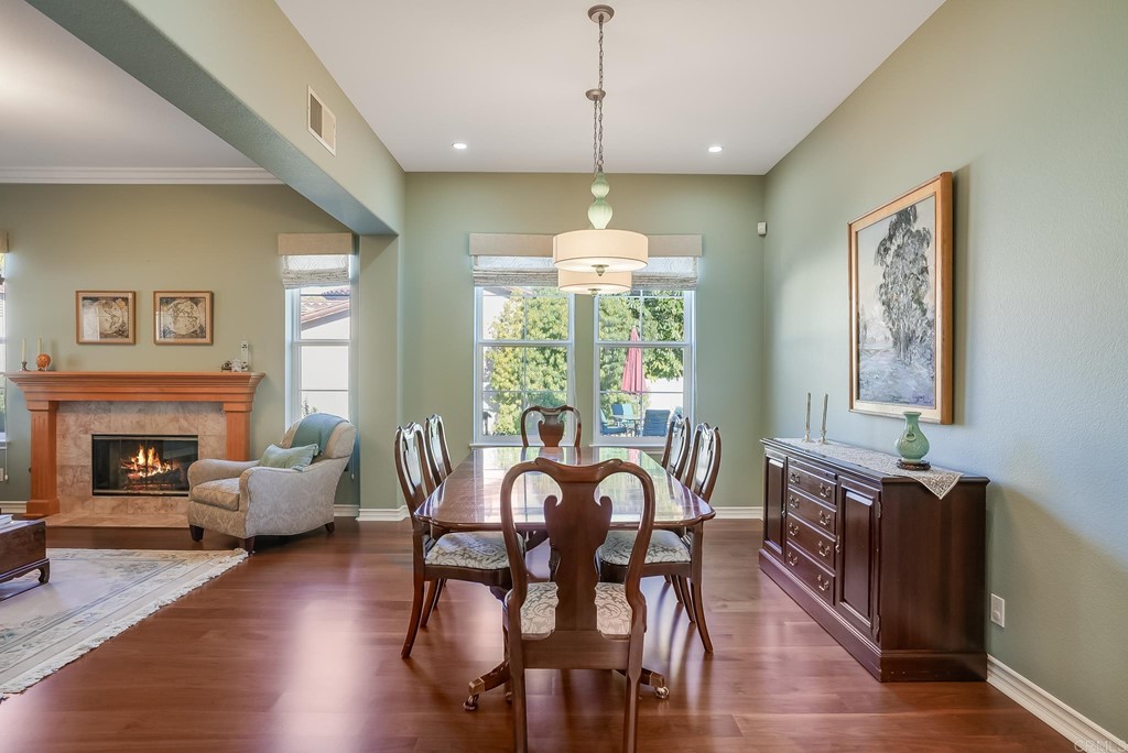 8046 Calle Pinon Carlsbad, CA 92009 - Photo 11 of 51 a view of a dining room with furniture window and wooden floor