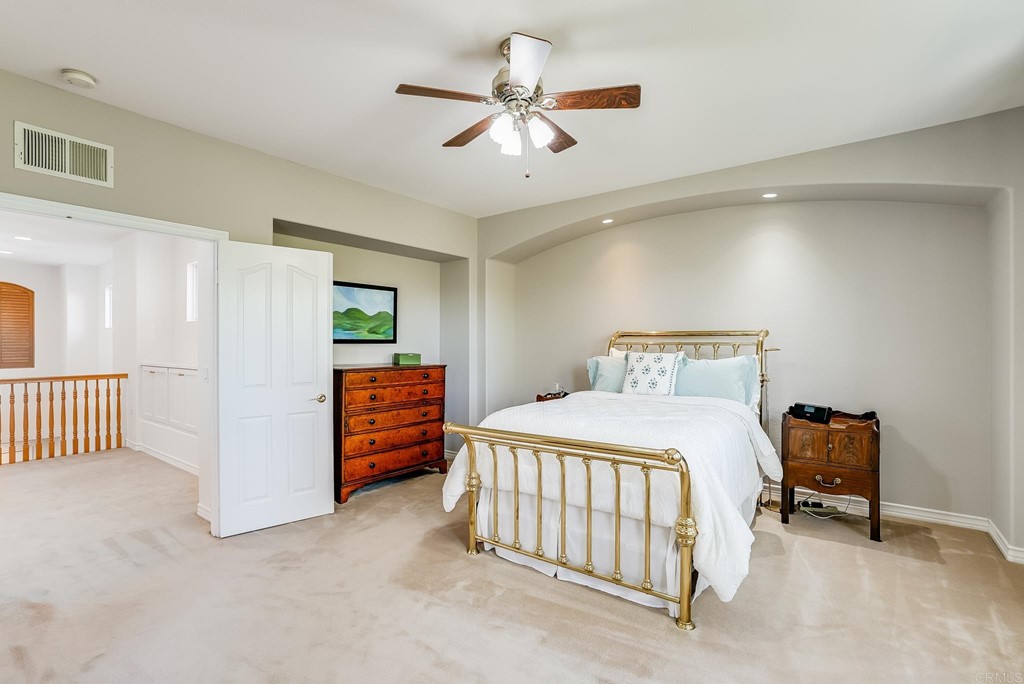 8046 Calle Pinon Carlsbad, CA 92009 - Photo 26 of 51 a bedroom with a bed and a chandelier