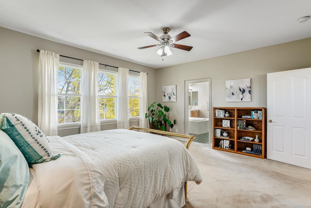 8046 Calle Pinon Carlsbad, CA 92009 - Photo 27 of 51 a bedroom with a large bed and a chandelier