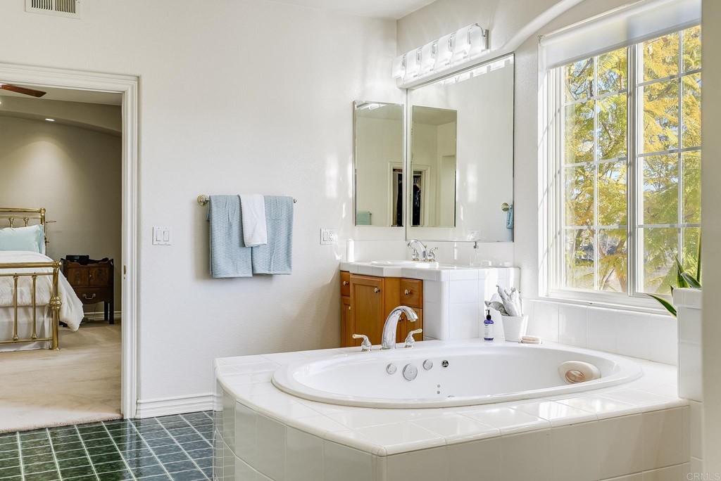 8046 Calle Pinon Carlsbad, CA 92009 - Photo 30 of 51 a bathroom with a tub sink and mirror