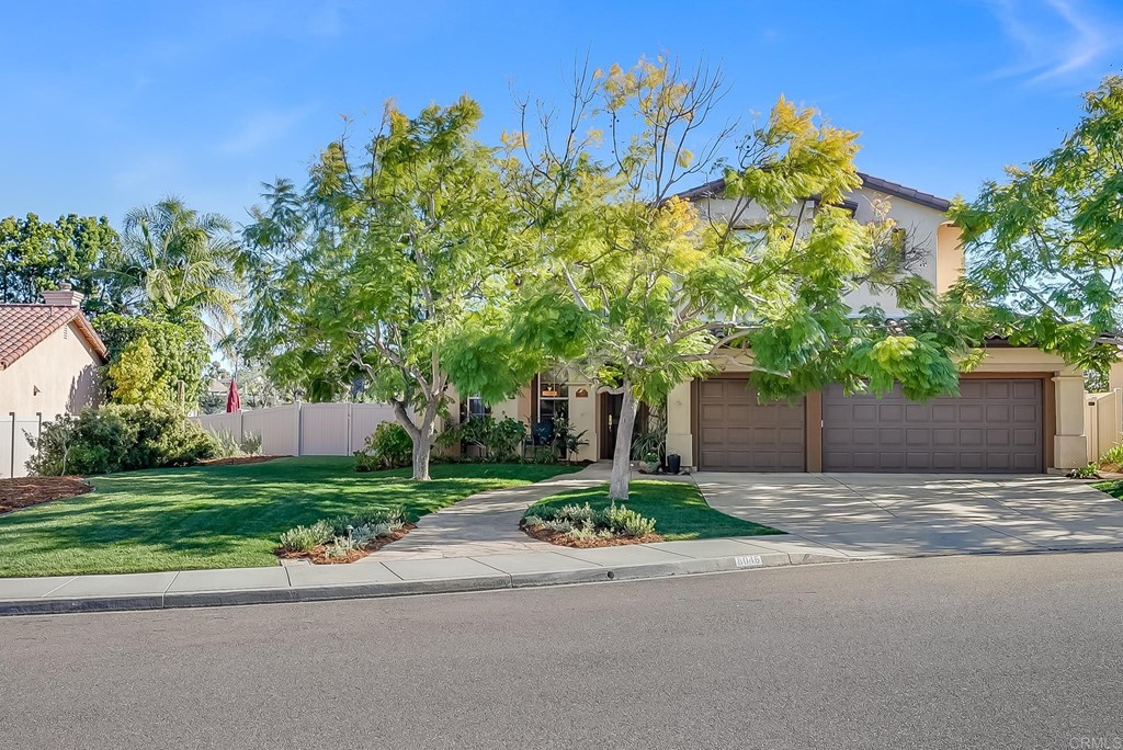 8046 Calle Pinon Carlsbad, CA 92009 - Photo 3 of 51 a front view of a house with a yard and garage