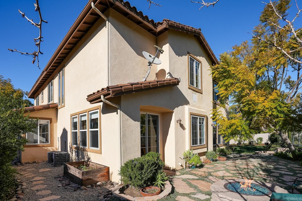8046 Calle Pinon Carlsbad, CA 92009 - Photo 41 of 51 a view of a white house with a large windows and flower plants