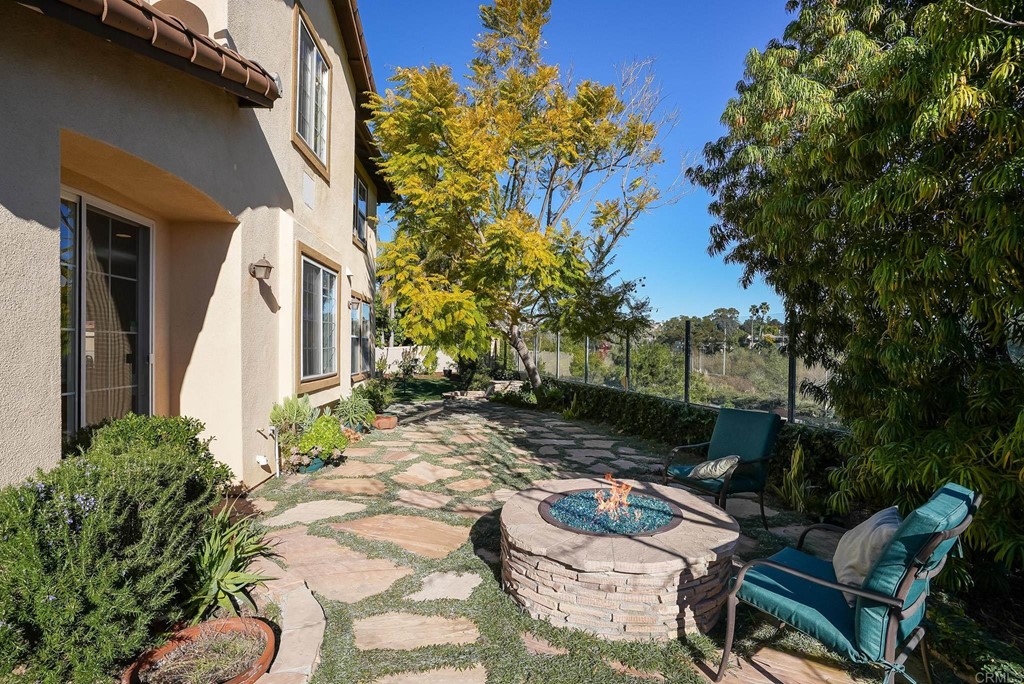 8046 Calle Pinon Carlsbad, CA 92009 - Photo 42 of 51 a backyard of a house with fountain table and chairs