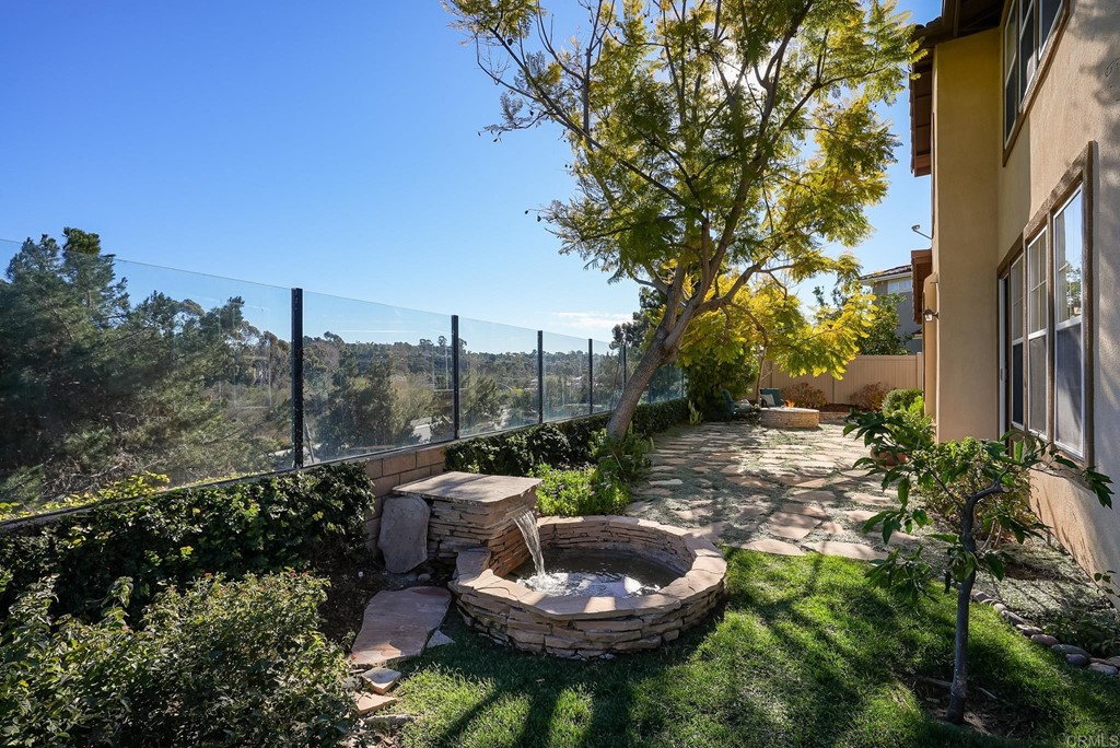 8046 Calle Pinon Carlsbad, CA 92009 - Photo 44 of 51 a backyard of a house with a fountain table and chairs