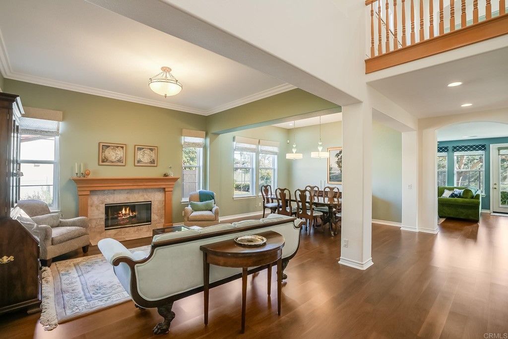 8046 Calle Pinon Carlsbad, CA 92009 - Photo 7 of 51 a living room with furniture a fireplace and wooden floor