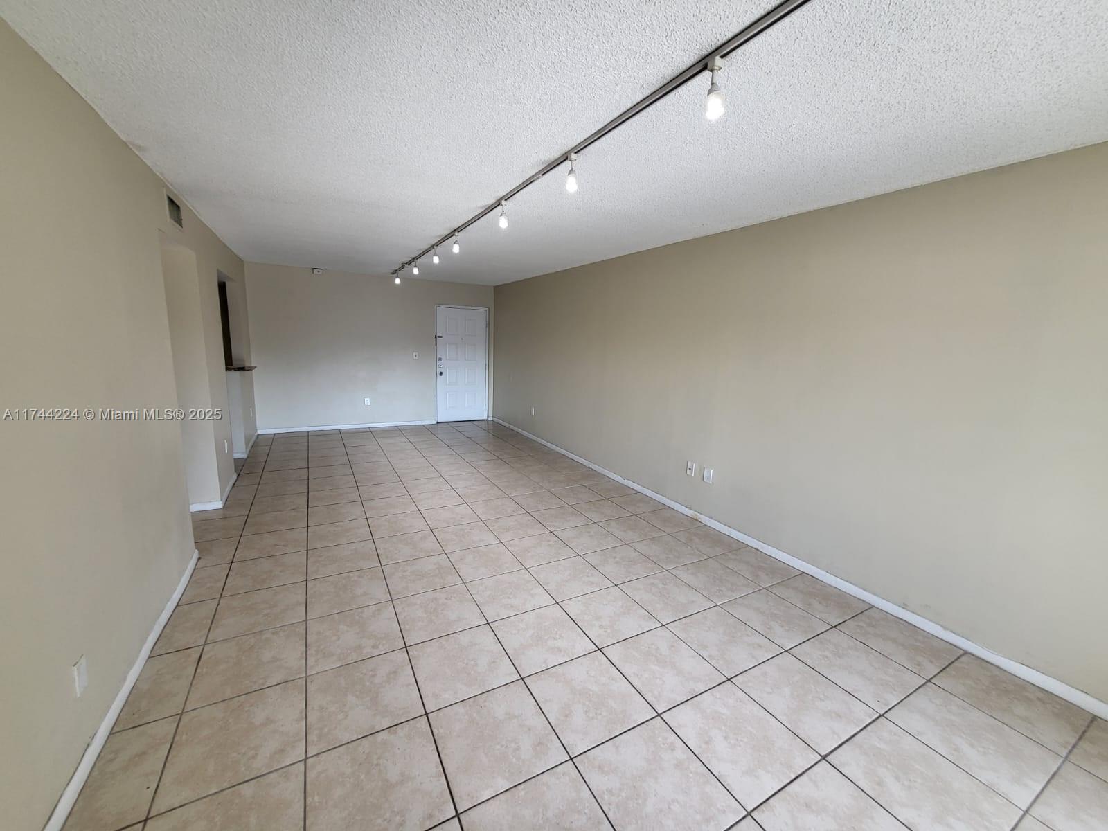 711 North Pine Island Road, Unit 407 Plantation, FL 33324 - Photo 4 of 11 an empty room with white walls and tiles