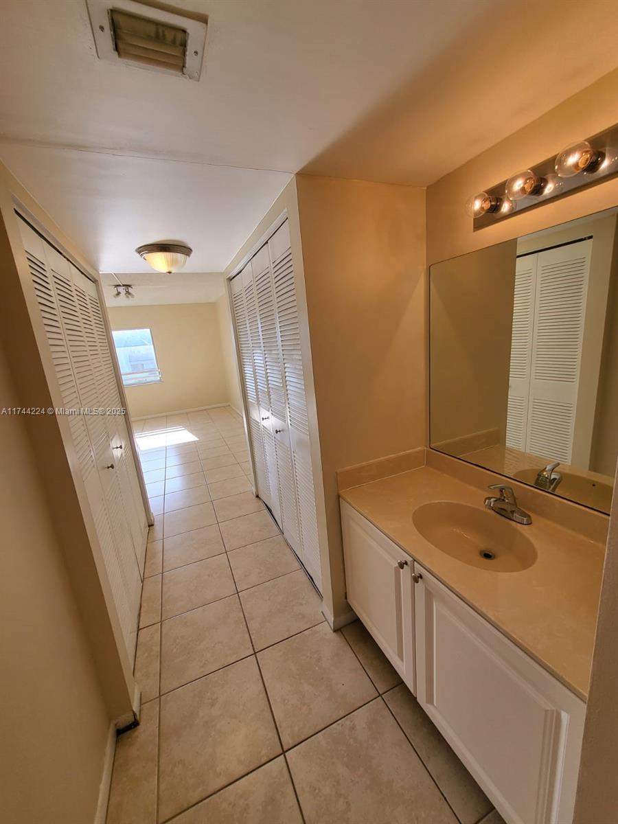 711 North Pine Island Road, Unit 407 Plantation, FL 33324 - Photo 10 of 11 a bathroom with a granite countertop sink and a mirror