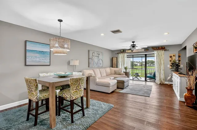 a living room with furniture a flat screen tv and wooden floor