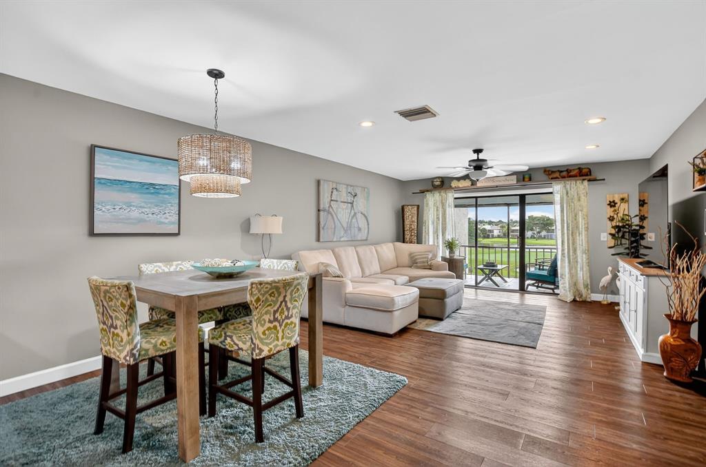 21219 Lago Circle, Unit J5 Boca Raton, FL 33433 - Photo 13 of 46 a living room with furniture a flat screen tv and wooden floor
