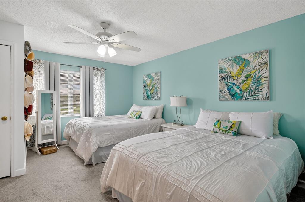 21219 Lago Circle, Unit J5 Boca Raton, FL 33433 - Photo 20 of 46 a bedroom with two beds and a chandelier