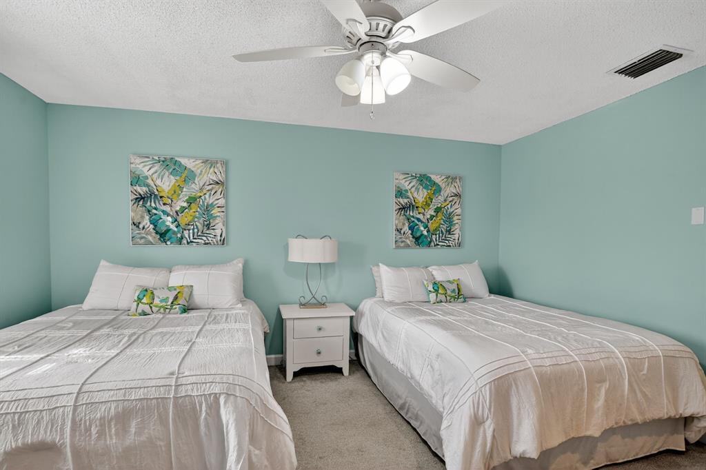 21219 Lago Circle, Unit J5 Boca Raton, FL 33433 - Photo 21 of 46 a bedroom with a bed and a chandelier