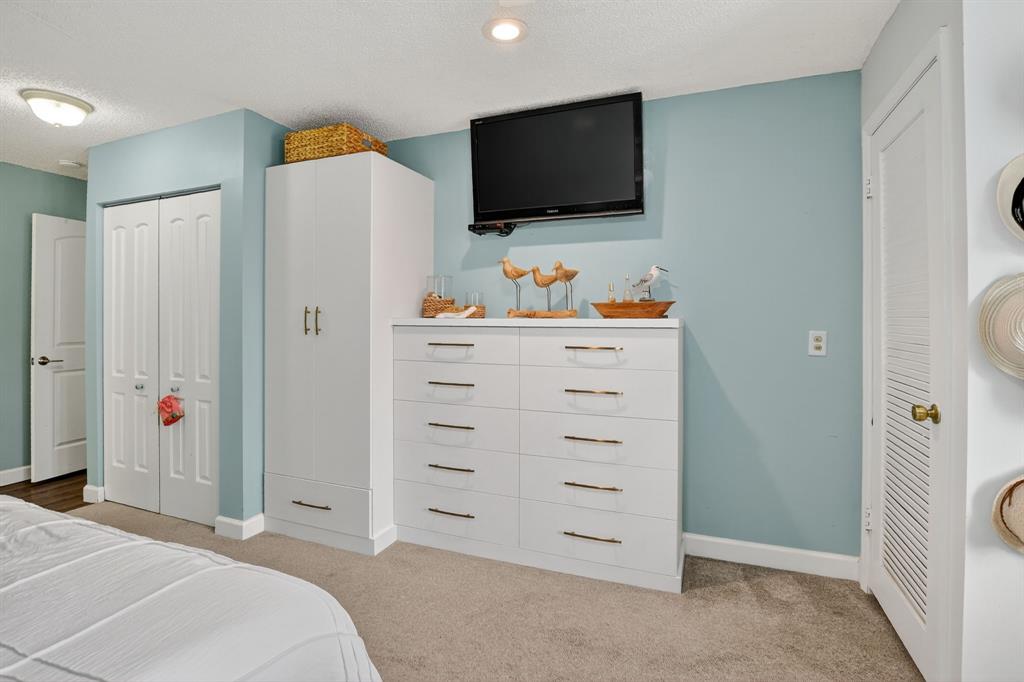 21219 Lago Circle, Unit J5 Boca Raton, FL 33433 - Photo 23 of 46 a bedroom with a bed and a flat screen tv