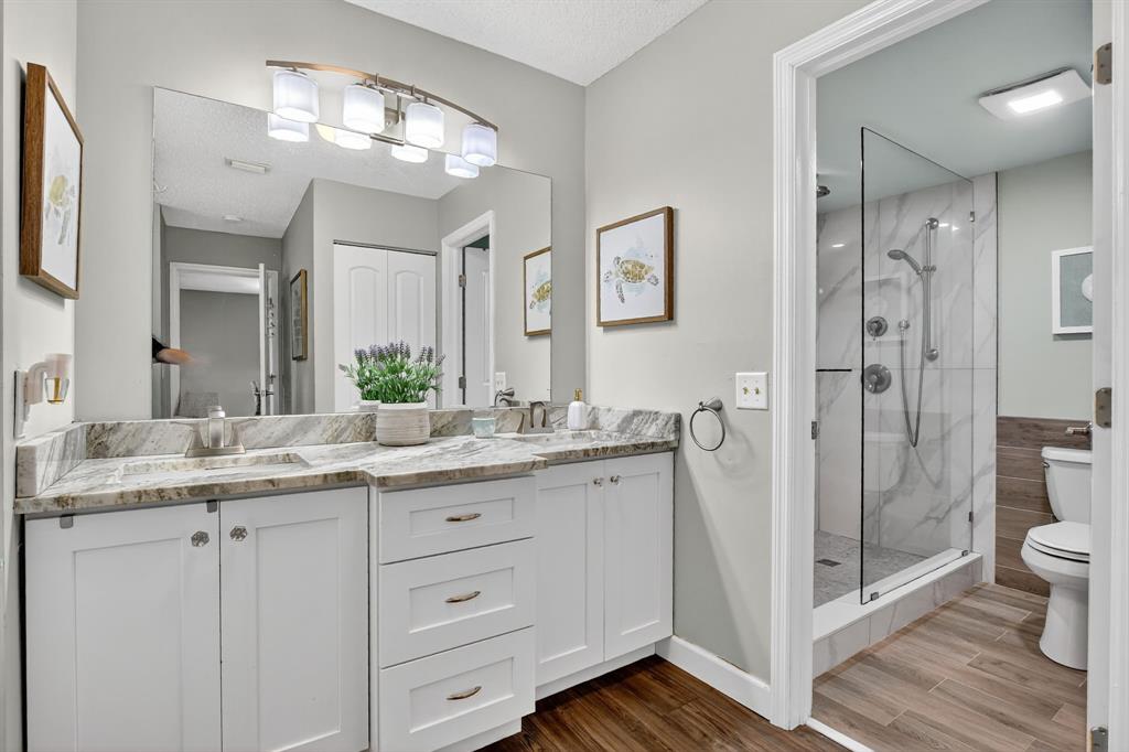 21219 Lago Circle, Unit J5 Boca Raton, FL 33433 - Photo 24 of 46 a bathroom with a granite countertop sink a toilet and shower