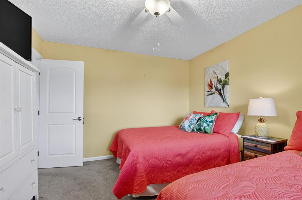 21219 Lago Circle, Unit J5 Boca Raton, FL 33433 - Photo 28 of 46 a bedroom with two bed and a flat screen tv