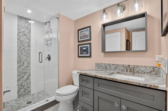 a bathroom with a granite countertop toilet sink and shower
