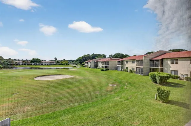 a front view of a house with a garden and lake view